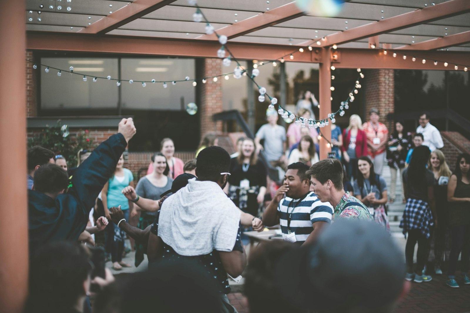 A church community gathered outdoors under string lights