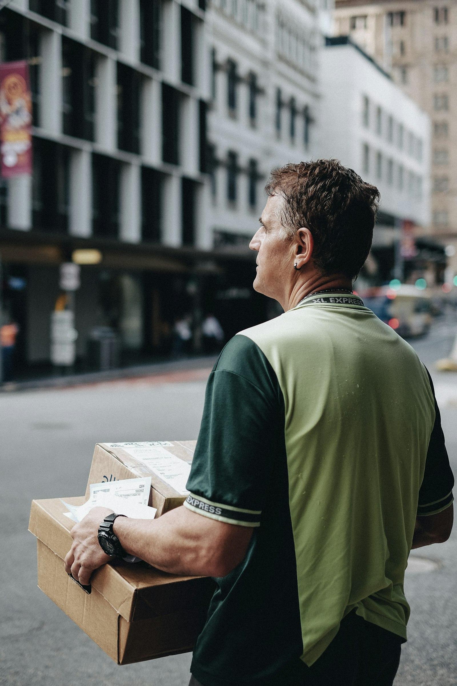 A delivery driver carrying packages on a city street