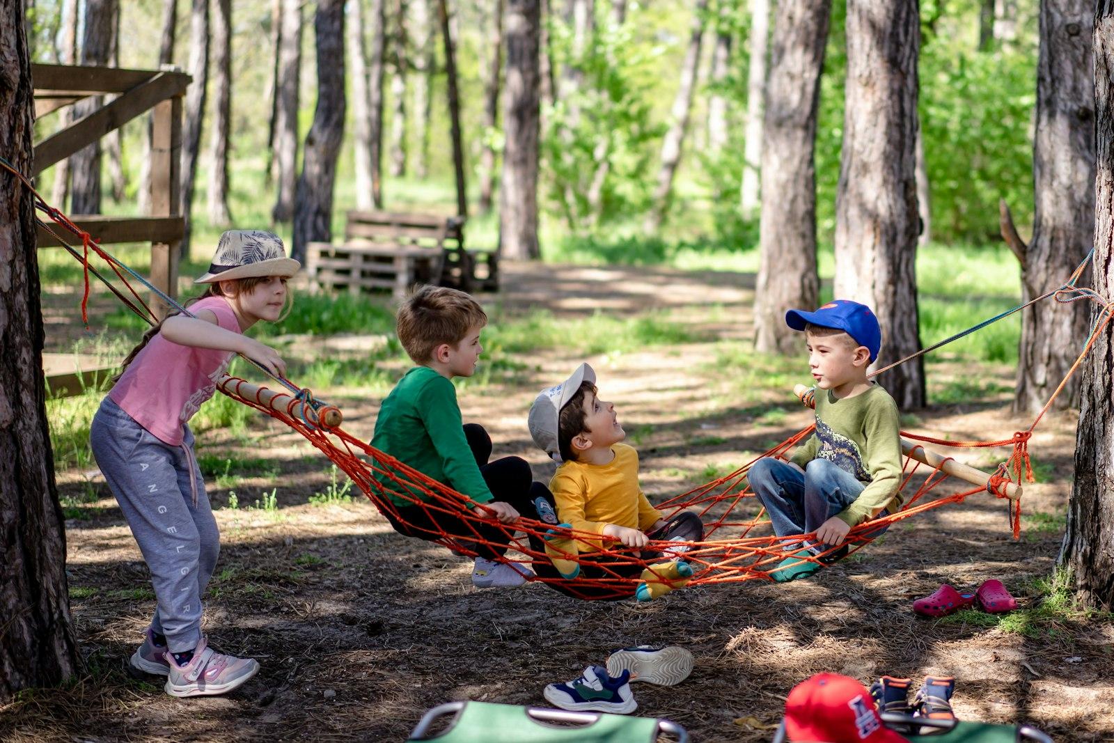 Kids relaxing in a hammock at a summer camp in the woods